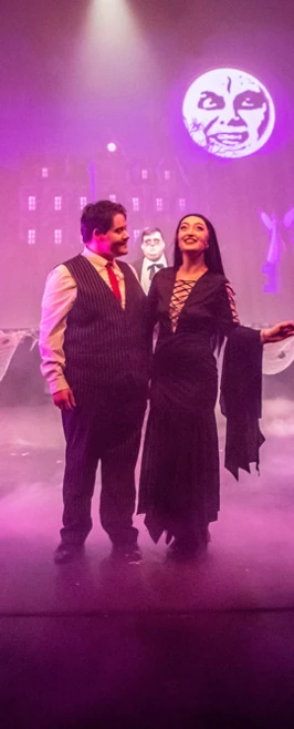 Cast of 'The Addams Family' standing united during a climactic moment under the projection of a spooky moon Cast of 'The Addams Family' standing united during a climactic moment under the projection of a spooky moon